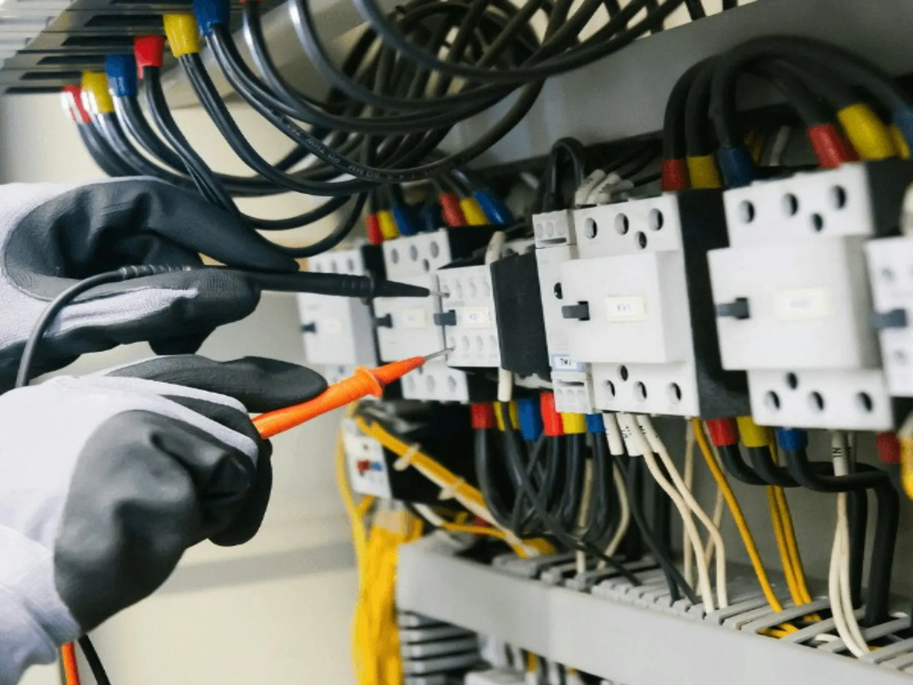 Électricien contrôlant un tableau électrique avec un tournevis testeur